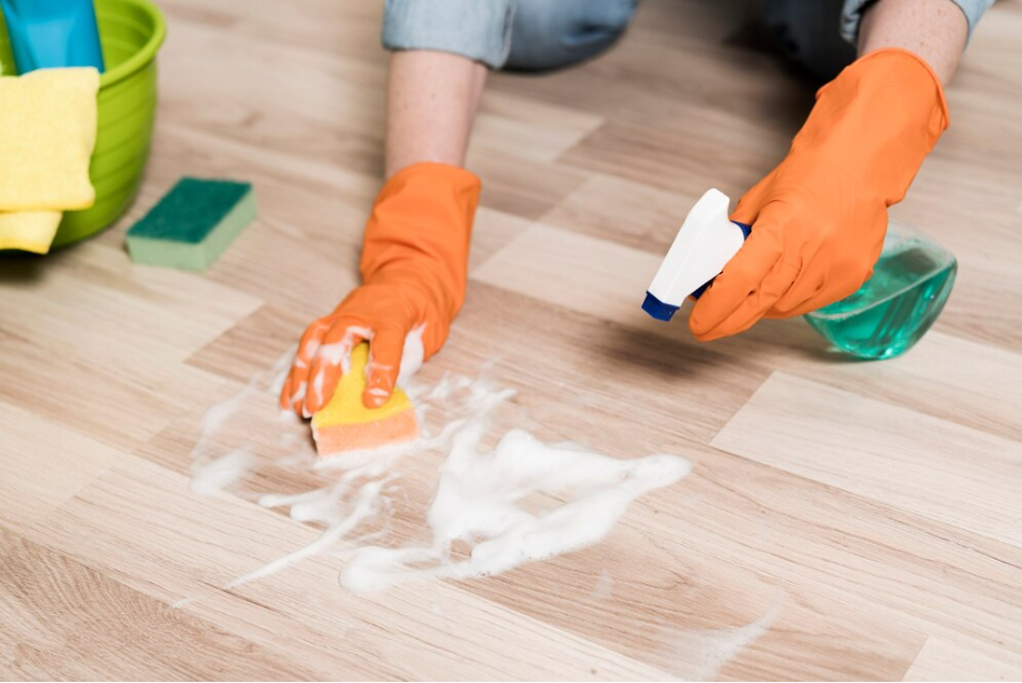 Man cleaning laminate floor with soft brush