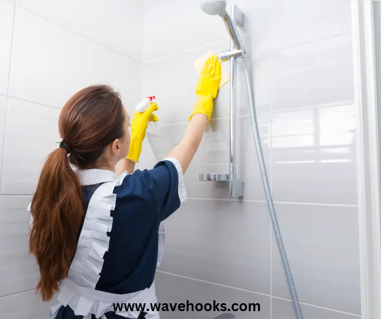 a girl cleaning the shower head without taking it off